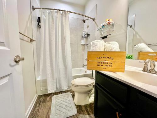 a white bathroom with a toilet and a sink at Lux Townhome Free Parking 12 min to BWI in Brooklyn Park