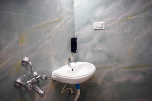 a bathroom with a white sink in a wall at The Nerd Nest Kolkata in Kolkata