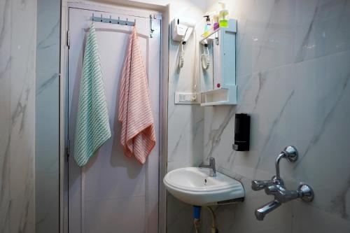 a small bathroom with a sink and a mirror at The Nerd Nest Kolkata in Kolkata