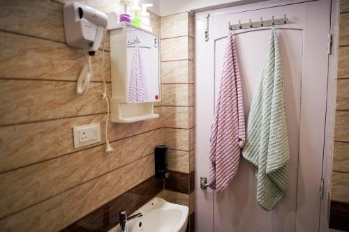 a bathroom with a sink and a white toilet at The Nerd Nest Kolkata in Kolkata