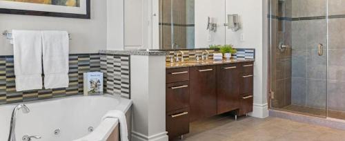 a bathroom with a tub and a sink and a shower at Las Vegas Desert Blue by HelloVacay in Las Vegas