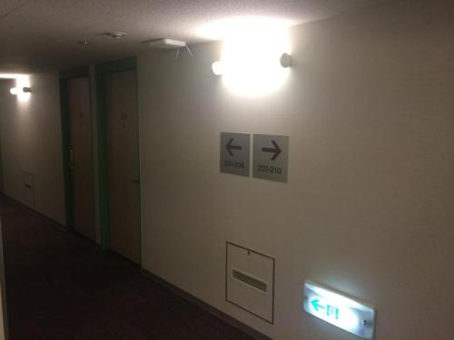a hallway with a sign on a wall with lights at R&B Hotel Hakata Ekimae 1 - Vacation STAY 40717v in Fukuoka