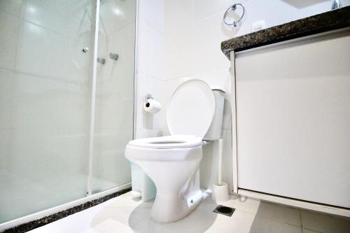a white bathroom with a toilet and a shower at Apto 19º andar, piscina, academia, garagem, ao lado do Shopping Salvador in Salvador