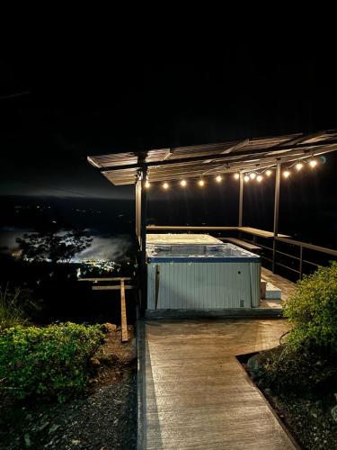 a hot tub on a deck at night with lights at Casa Linda Vista in Caño Seco