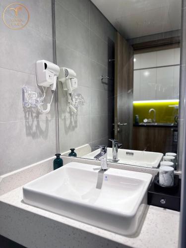 a bathroom with a white sink and a mirror at Armin Homes Studio at Solforest Ecopark in HÆ°ng YÃªn