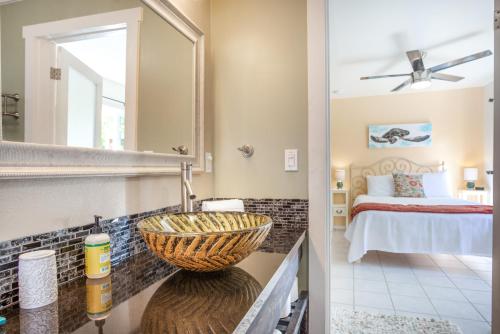 a bathroom with a sink and a bedroom at Pahoa Sunrise Paradise Gardens in Pahoa