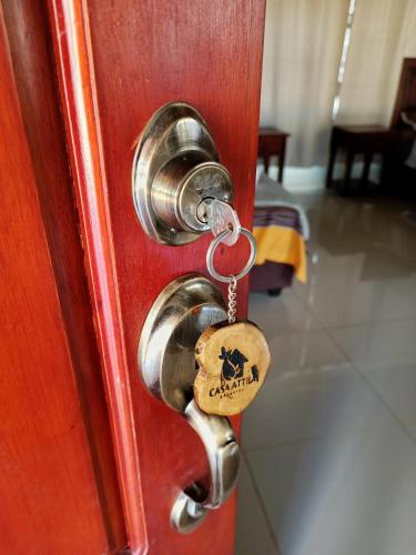 a lock on a door with a dog tag on it at Casa Attila Sarapiquí in Sarapiquí
