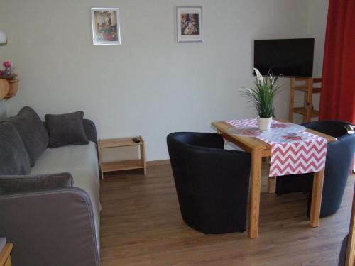 a living room with a table and a couch at Pokoje i apartamenty pod Jaworzyną w Koninkach in Koninki