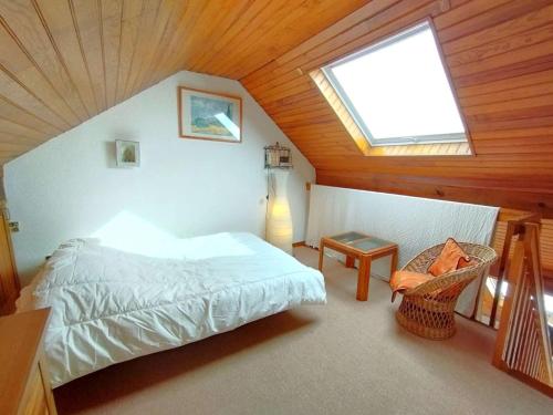 - une chambre avec un lit et une fenêtre mansardée dans l'établissement T2 cosy pour 6 personnes à Saint-Lary-Soulan avec parking - FR-1-457-347, à Saint-Lary-Soulan