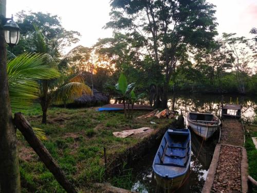 two boats are docked on a river with trees at Sconfra creek in Bluefields