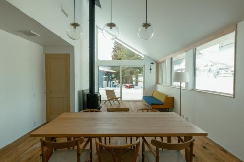 a dining room with a wooden table and chairs at JOKIJOKI Hakuba in Hakuba