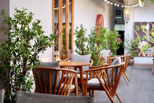 a table and chairs in a restaurant with plants at Moorea Boutique Resort Samui in Ban Tai