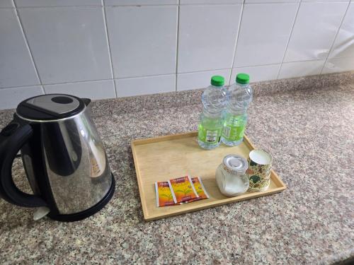 a cutting board with two bottles of water and a kettle at فندق عين مجان للشقق الفندقية in ‘Ibrī