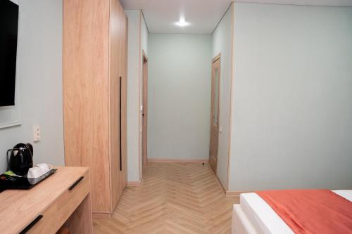 a bedroom with a bed and a hallway with a closet at Terrenkur boutique-hotel in Almaty