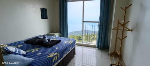 a bedroom with a bed and a large window at SMDC Tagaytay Taal Lake Condo Cook Netflix No Balcony No Free Parking Contact to Confirm in Tagaytay