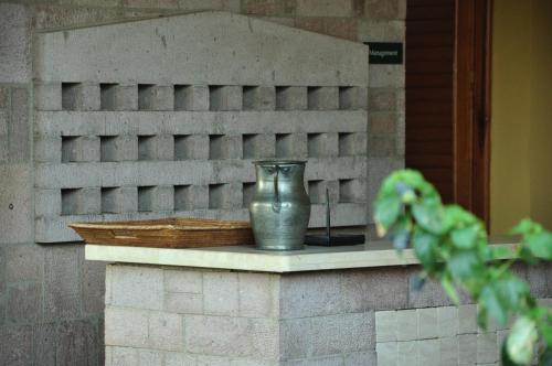 a metal vase sitting on a brick wall at Palm Court Suites in Ayvalık