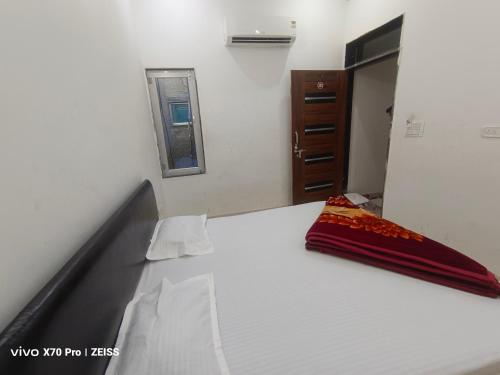 a bedroom with a large white bed and a mirror at Aasha Place Khatu Shyam ji in Khātu