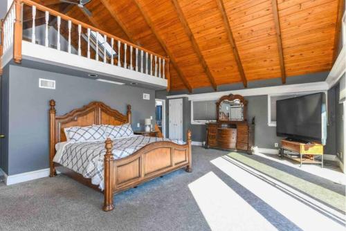 a bedroom with a bed and a flat screen tv at Villa on a hill with indoor heated salt water pool in Boyertown