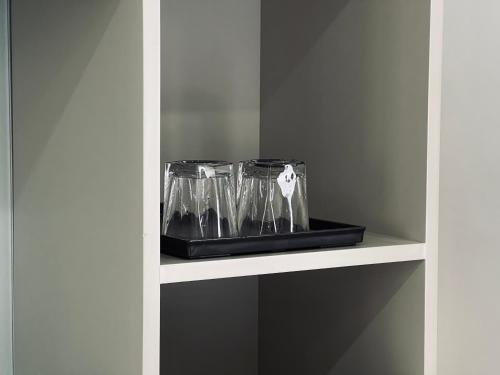 a shelf with glasses on it in a kitchen at Cat Ba Seoul 2 Hotel & Apartment in Cat Ba