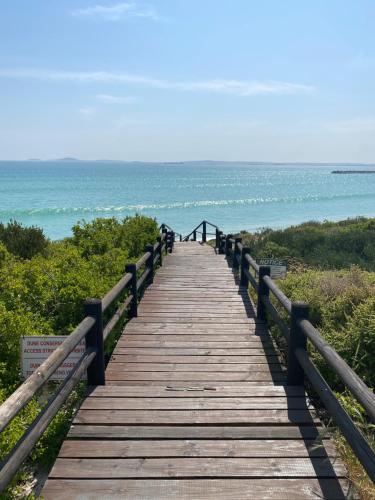 a wooden boardwalk leading to the ocean on a beach at Barefoot at Calypso Beach in Langebaan