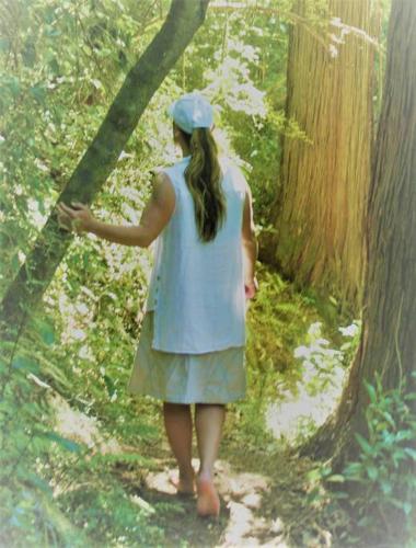 a woman in a blue dress walking in the woods at Star Gaze From Your Bed in Fairlie