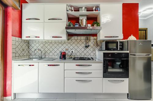 a white kitchen with white cabinets and appliances at Margottini House Airport in Fiumicino
