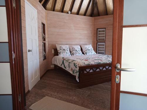 a small bedroom with a bed in a room at Fare Mama Fenua plage baleines Moorea Temae in Teavaro
