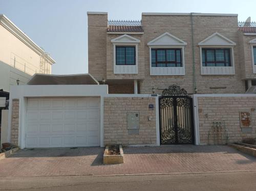 迪拜Elegant Villa Rooms in Dubai near Airport的砖屋,设有大门和车库