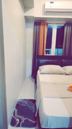 a small bedroom with two beds and a window at Staycation by Estelle in Manila