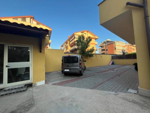 a van parked in a parking lot next to a building at Margottini House Airport in Fiumicino