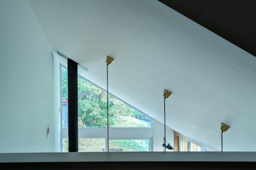 a room with a large window and three lights at JOKIJOKI Hakuba in Hakuba