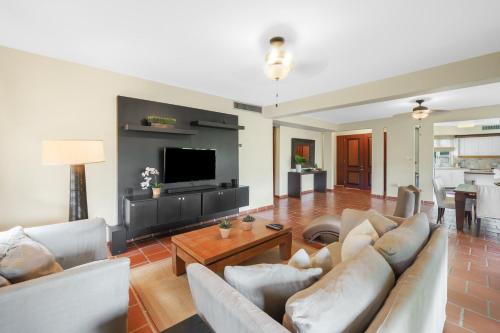 a living room with two couches and a tv at Family Villa Oleana Waterviews Oceanfront with water and generator in Vega Alta