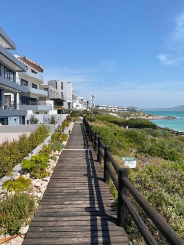 a wooden boardwalk leading to a beach with condos at Barefoot at Calypso Beach in Langebaan