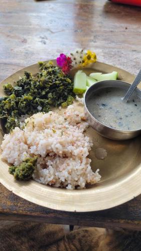 een bord rijst en groenten en een kom dip bij Basanti Rawat Homestay in Munsyari