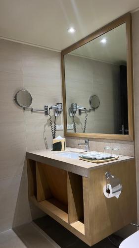 a bathroom with a sink and a large mirror at Taal Vista Hotel in Tagaytay