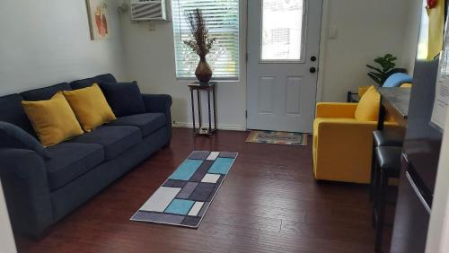 a living room with a blue couch and yellow pillows at Guestsuite in wittier in Whittier