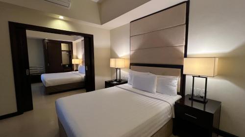 a hotel room with a large bed and a mirror at Taal Vista Hotel in Tagaytay