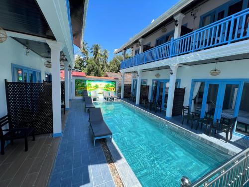 a swimming pool with chairs and a building at Sadakham Royal View Hotel in Luang Prabang