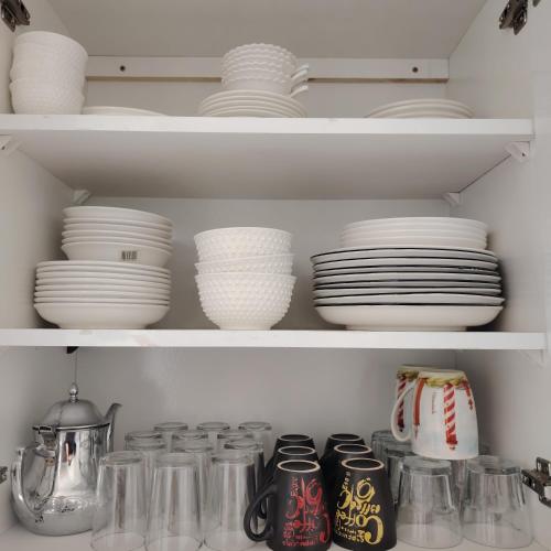 a shelf filled with plates and bowls and dishes at Élégance familiale à Skhirate près de la plage et la ville in Skhirat