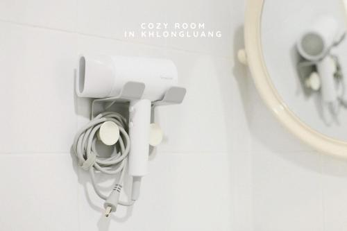 a bathroom with a mirror and a white phone at Cozy room in Khlongluang Ill - Self Check-in in Khlong Luang