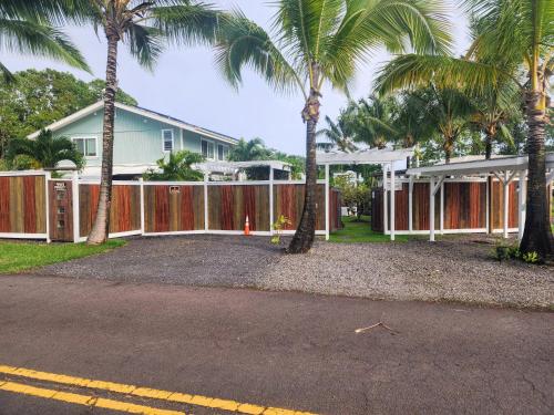 a house with palm trees in front of it at Pahoa Sunrise Paradise Gardens in Pahoa