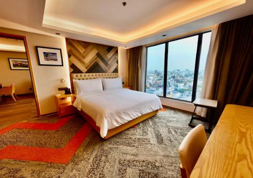 a hotel room with a bed and a large window at HANSA- A Premium Residence in Dhaka