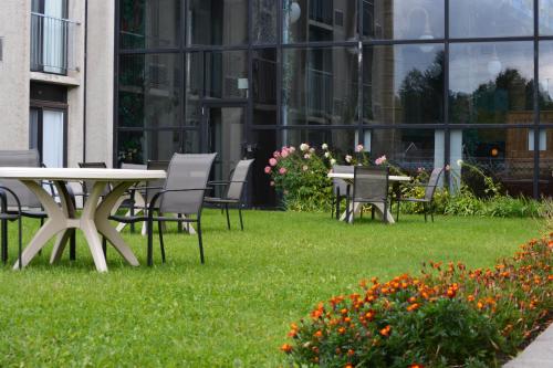 a table and chairs in the grass in front of a building at La Saguenéenne - Hôtel et Centre de Congrès in Saguenay