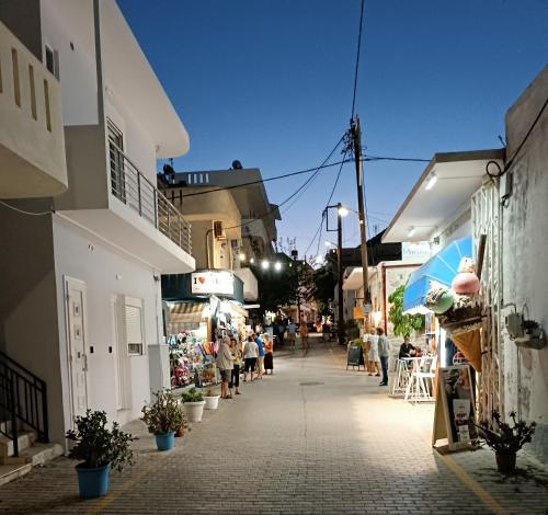 a street with a group of people walking down a street at Roummi Suite Mirtos in Myrtos