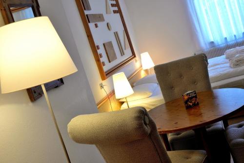 a room with a table and chairs and a lamp at Parkhotel Sole Paradiso in San Candido