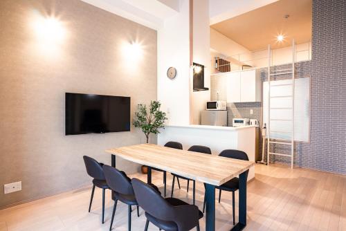 a dining room with a wooden table and chairs at Hie Apartment in Fukuoka