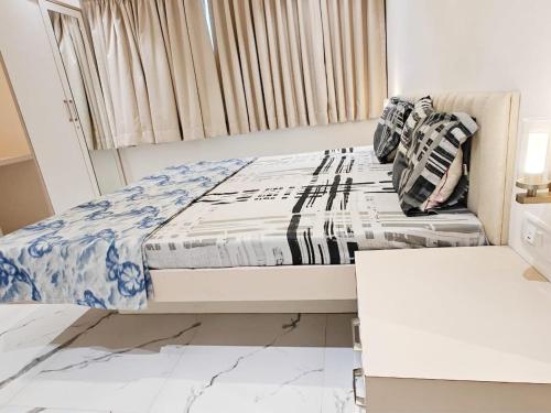 a small bedroom with a bed with blue and white sheets at Mizzle Exotica Lonavala in Lonavala