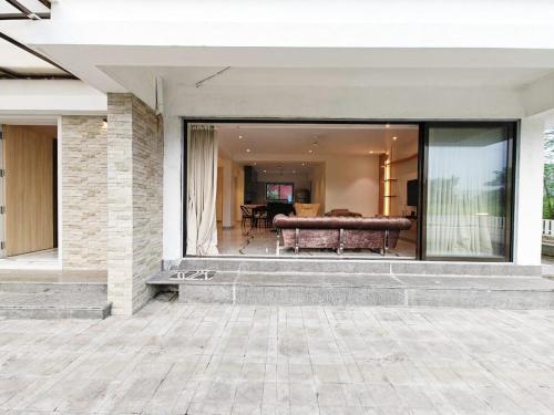 a large glass window of a house with a bench at Mizzle Exotica Lonavala in Lonavala