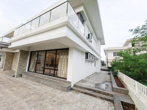 a white house with a balcony and a patio at Mizzle Exotica Lonavala in Lonavala