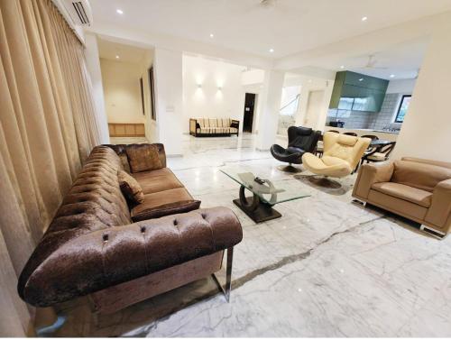 a large living room with a couch and chairs at Mizzle Exotica Lonavala in Lonavala